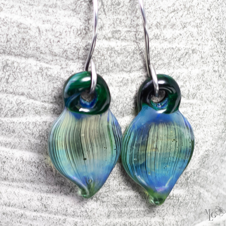 Lampwork glass earrings in a petal shape dangling from stainless wire. The colors are a marvelous blend of ocean colors
