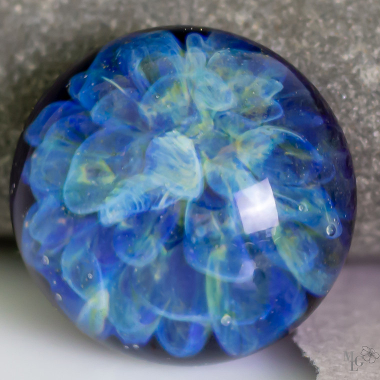 Whisper soft palette of light yellow and blue backed by midnight blue. This handcrafted lampwork glass cabochon is 22mm