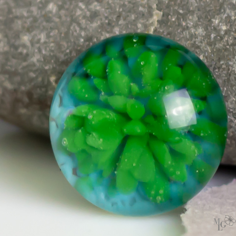 Bright green center with a cherry aqua background. This little 16mm implosion cabochon is a happy one