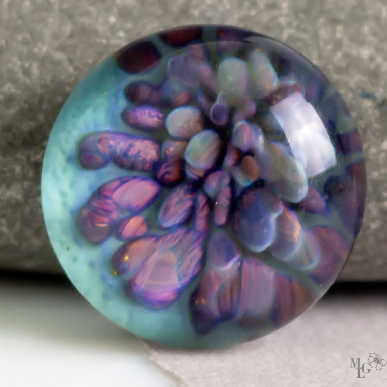 Hues of purple, blue, aqua and a hint of sage green bring this boro glass cabochon bloom to life! It measures 24mm