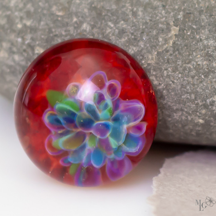 Happy as a flower in blooming in spring. This little 16mm red glass cabochon has fresh from the garden colors that collect on one side of the bead to form a flower bloom