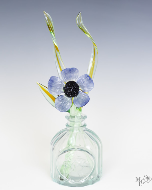 Single Tranquil blue glass  bloom with accompanying slender green leaves ready to reside in your favorite little bud vase