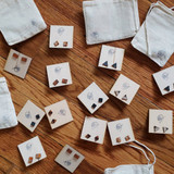 Leather studs on a wooden earring card with muslin bag