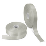 A roll of personalised ribbon in a soft, pale green colour alongside another roll, both on spools.