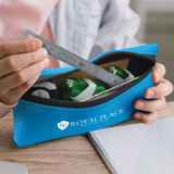 A blue pencil case with a zipper, containing a ruler and green highlighters, held by a person. Features a logo.