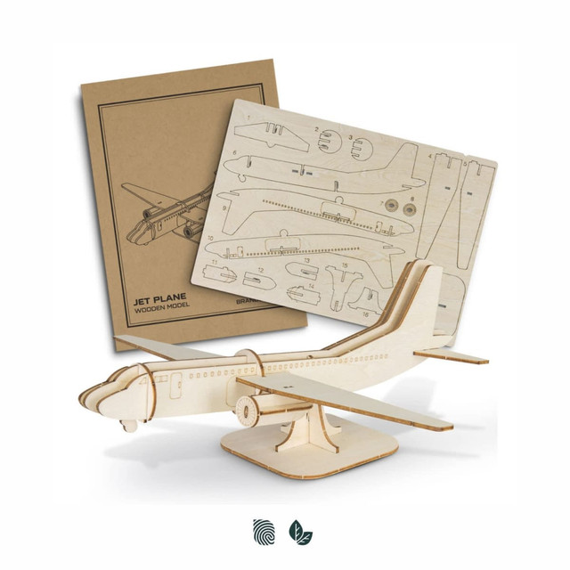 A wooden model of a jet plane with a light wood finish, accompanied by assembly instructions.
