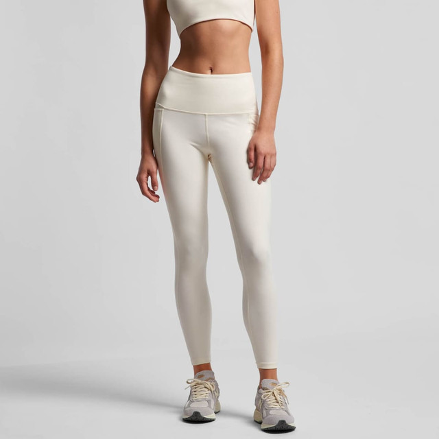 Cream-coloured active leggings with a high waistband, paired with a matching crop top. The model is wearing athletic shoes.