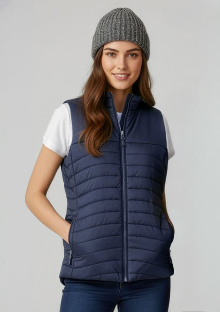 A navy womens expedition vest with a zip front, featuring a padded design and two side pockets. Worn with a grey beanie.
