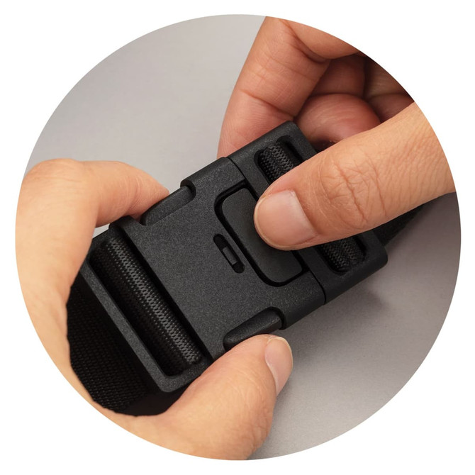 A hand pressing the release button on a black adjustable buckle, part of an Urban Belt Bag.