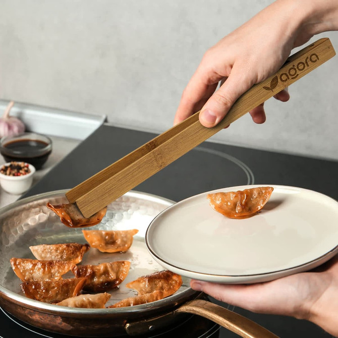 Bamboo serving tongs in a rectangular kraft paper box with a logo, featuring a natural wood finish.