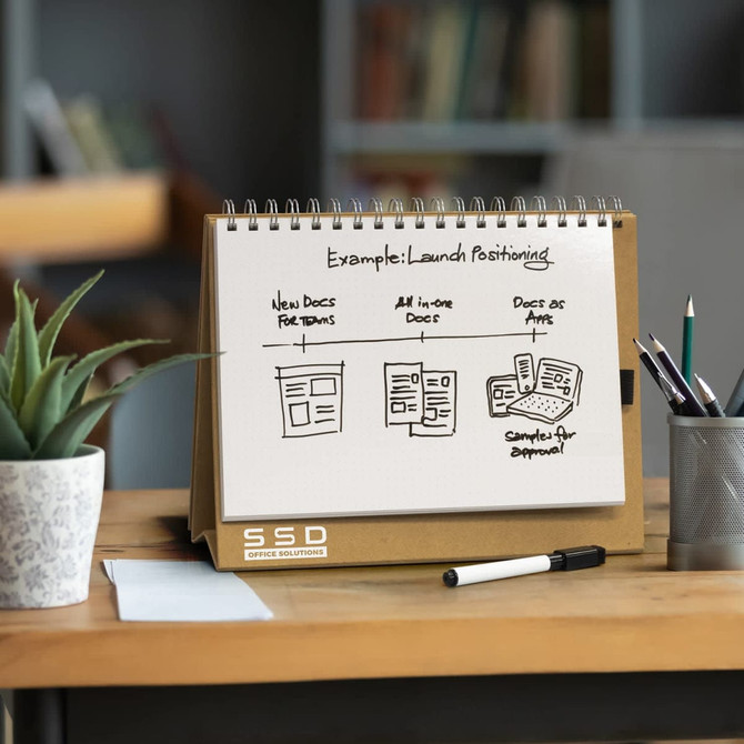 A desk whiteboard notebook with a spiral binding on a wooden surface, displaying diagrams in black ink. It includes a logo.