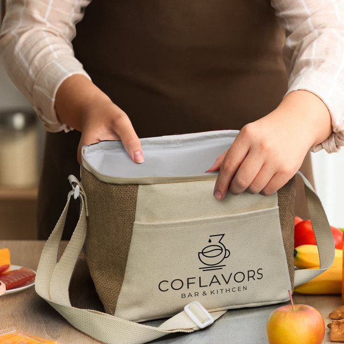 A jute cooler bag in natural and cream colours, featuring a logo, being held by a person with hands inside.