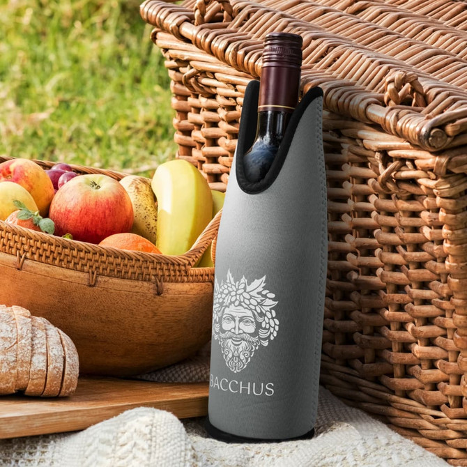 A drink bottle cooler in grey features a logo and is positioned next to a woven basket filled with fruits.
