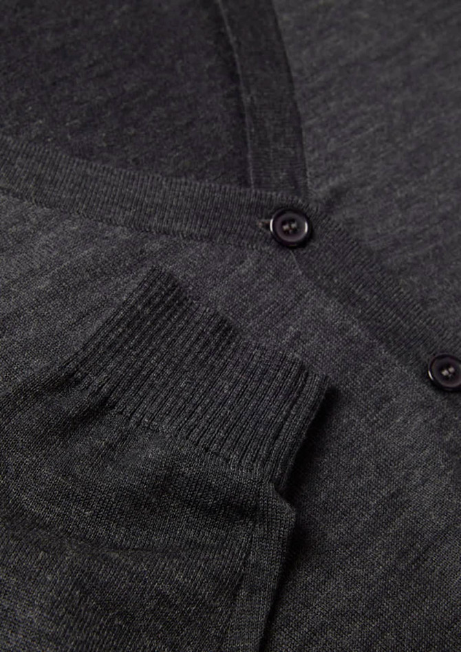 A grey women's button front knit cardigan featuring a pocket and button detail. It includes a logo.