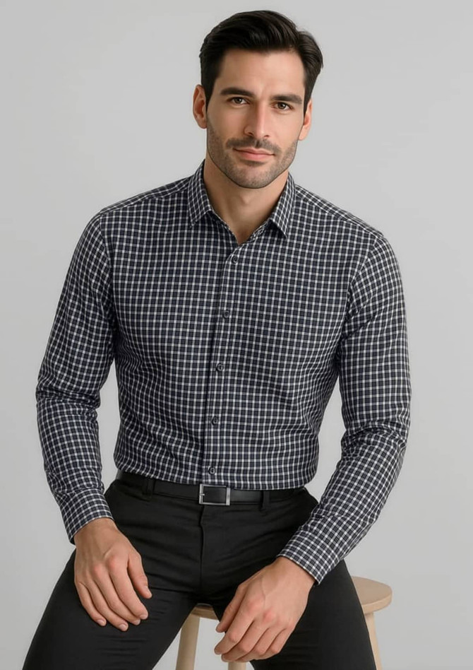 A long-sleeve, button-up shirt in a black and white check pattern, worn by a man sitting on a stool.