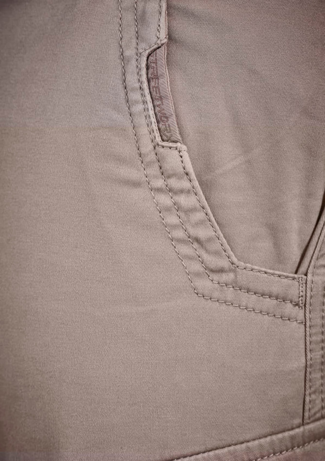 Close-up of a pair of men's cargo pants in a light beige colour, featuring a side pocket. The pants have a textured fabric.