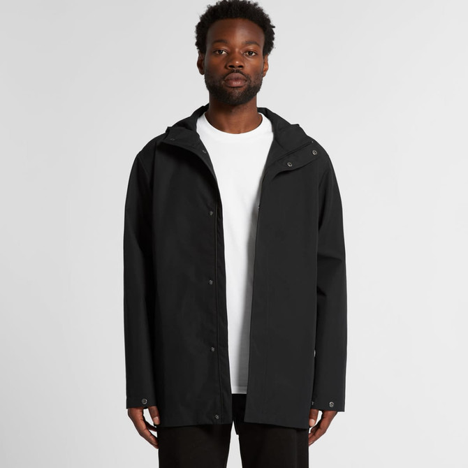 A black rain jacket with a hood, featuring a front zip and snap closure, modelled by a person.