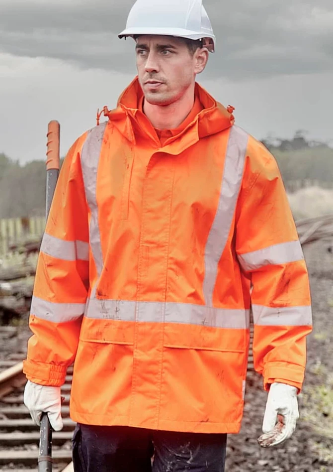 An orange waterproof jacket with reflective stripes, worn by a man in a hard hat and gloves, set against a cloudy background.