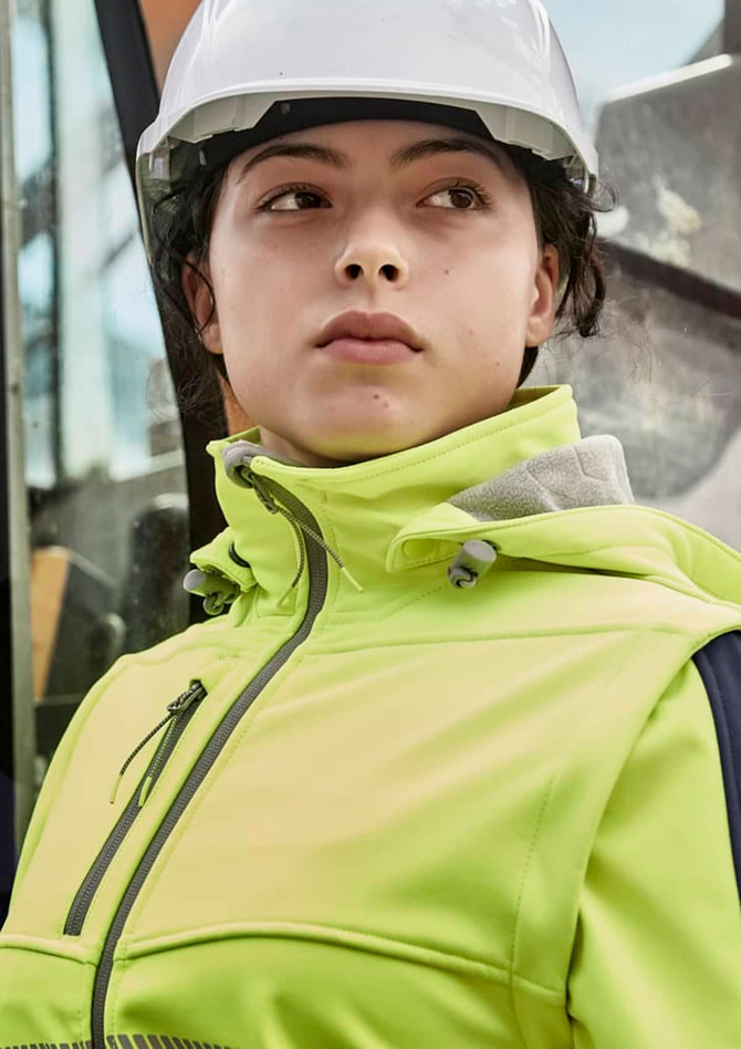 A women's bright yellow stretch softshell jacket with a hood, worn by a person in a hard hat.