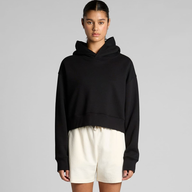 A black cropped hoodie with a hood and long sleeves, styled casually with light-coloured shorts.