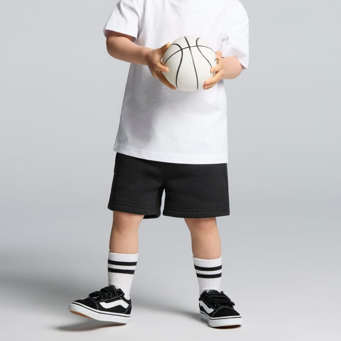 Black track shorts worn with a white T-shirt and black sneakers, holding a basketball. The outfit includes striped socks.