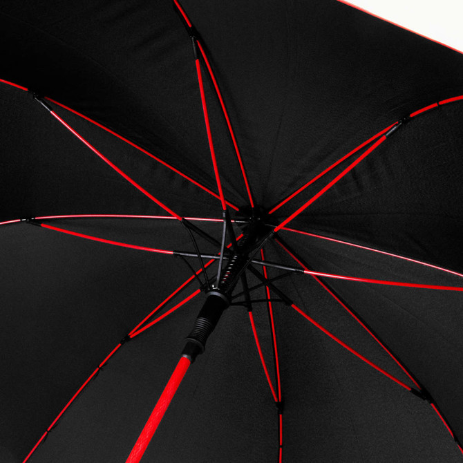 A black umbrella with red accents, featuring a detailed view of its interior structure and ribs.