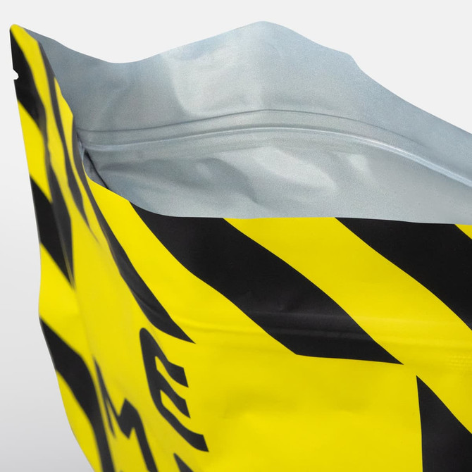 A large foil flat bottom pouch with a striking yellow colour and a black graphic design, featuring a zippered top and a logo.