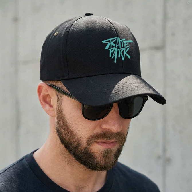 A black cap with a turquoise logo, featuring a curved brim and ventilation holes, worn by a man with sunglasses.