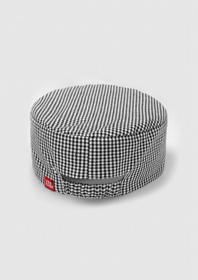 A black and white checked chef cap with a branding label on the side.