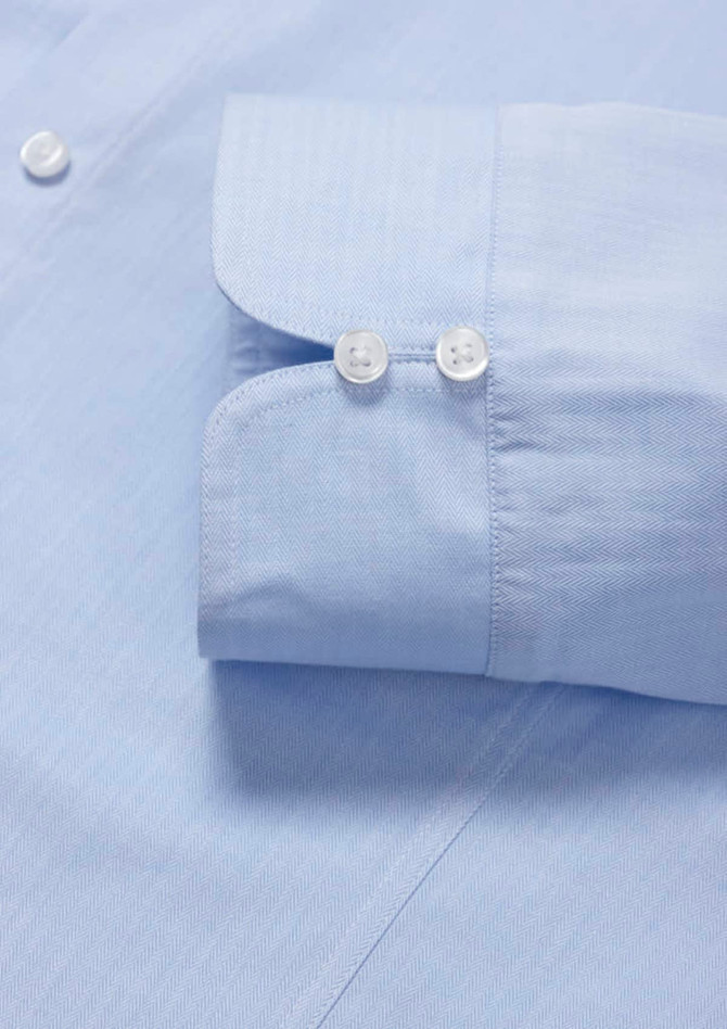 A light blue women's luxe long sleeve button-up shirt featuring a double cuff design and buttons.