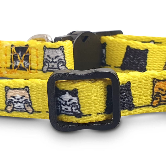 A yellow cat collar featuring various cartoon cats in shades of grey, black, and orange with a black buckle.