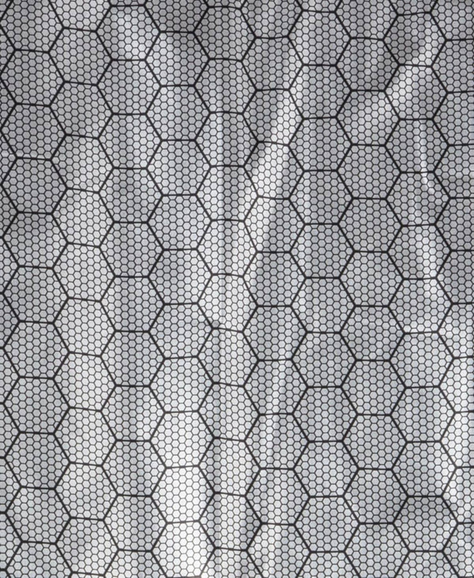 A textured fabric featuring a hexagonal pattern in black and grey, typical for outdoor vests.