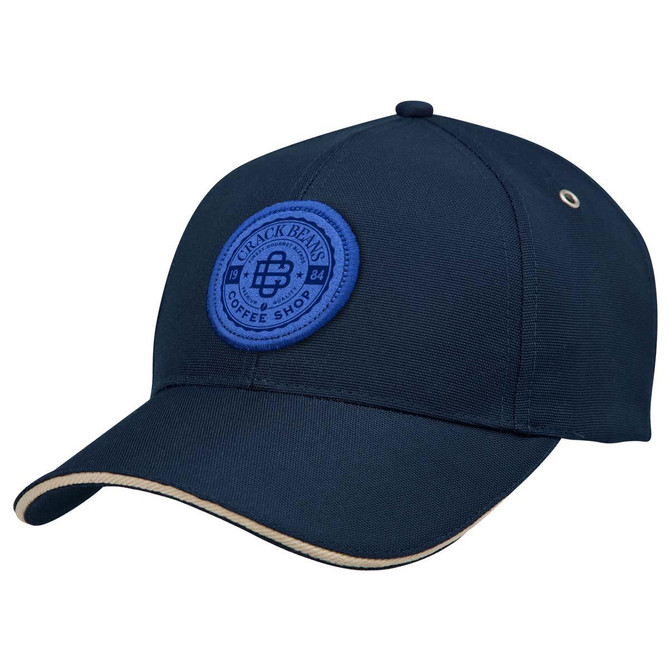 A navy cap with a round blue logo patch and a cream-coloured brim. Features include a structured design.