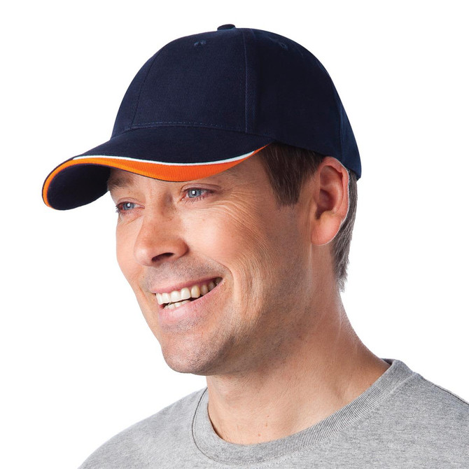 A navy blue cap with an orange accent, featuring a logo, being worn by a smiling man.