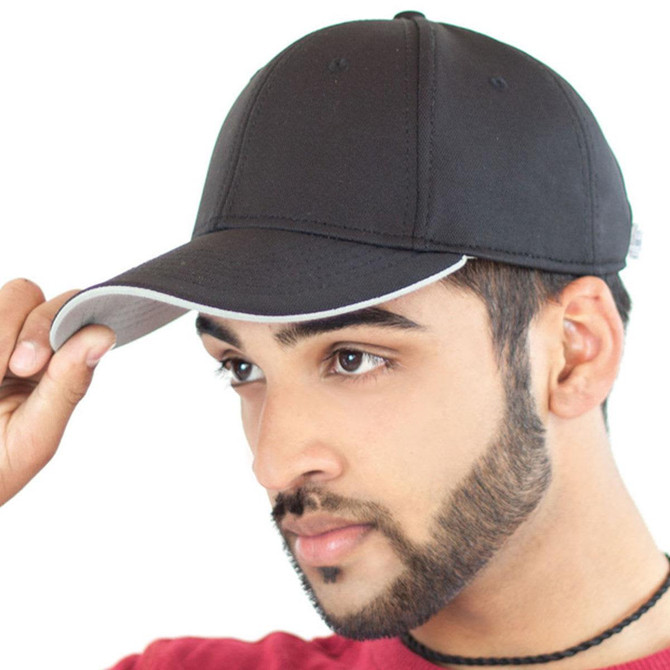 A black cap with a grey underside, featuring a logo at the side. The cap is worn by a young man.