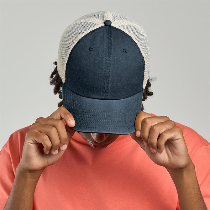 A navy blue trucker cap with a light-coloured mesh backing. It features a logo on the front.