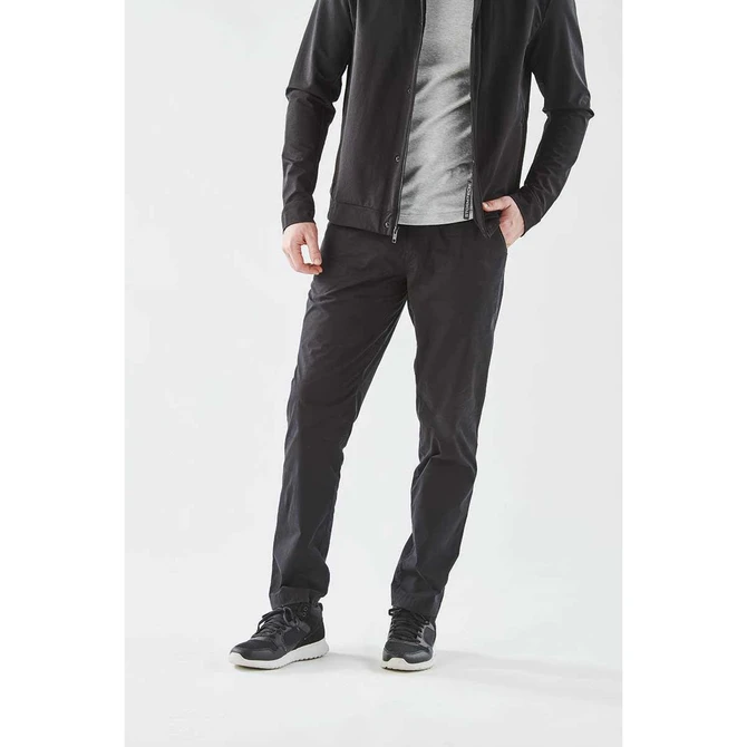 Men's Soho Performance Pant in black, featuring a sleek design and a logo, styled with a grey top and black shoes.