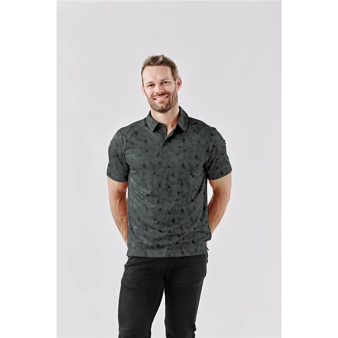 A man wearing a dark green patterned polo shirt with a collar. The shirt features a logo.