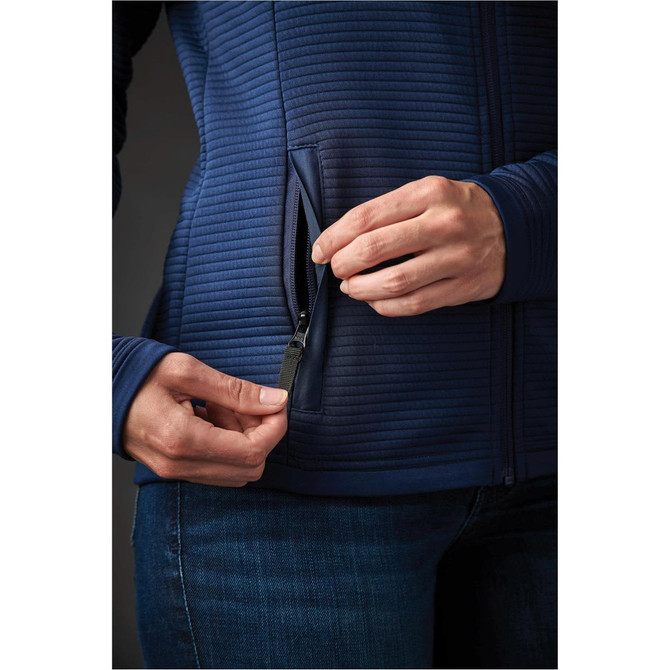 A woman’s hand adjusts the zipper on a navy blue, textured Women's Andorra Jacket with side pockets.