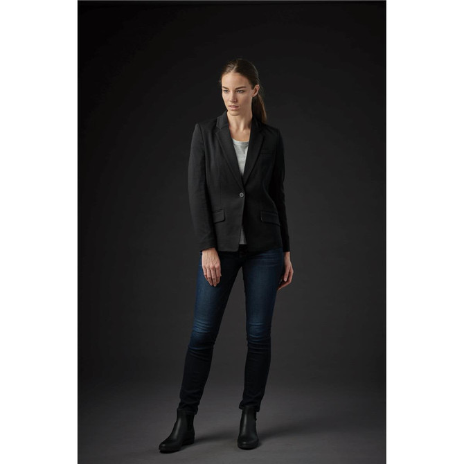 A women's black knit blazer with a single button, worn over a light top and paired with dark jeans and ankle boots.