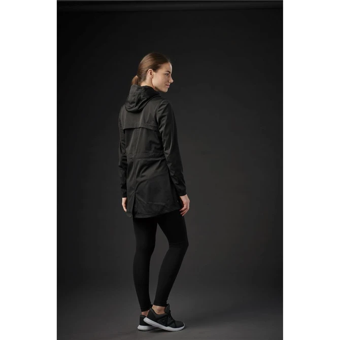 A woman in a black softshell jacket with a hood, paired with black leggings and trainers, facing away from the camera.
