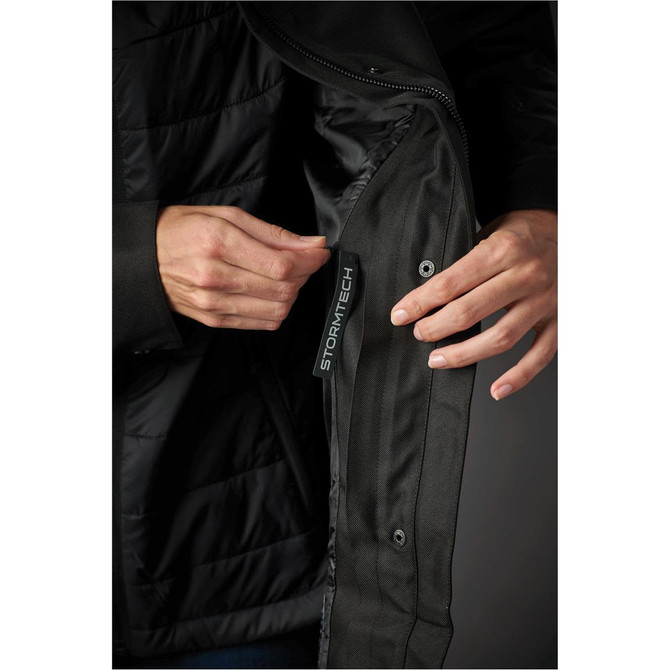 A women's jacket featuring a black outer layer and an interior pocket with branding.
