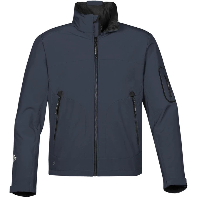 A men's softshell jacket in navy blue with a high collar and multiple zippered pockets. It features a logo on the sleeve.