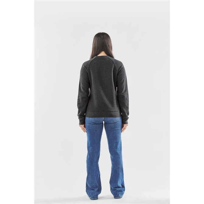 A woman stands with her back to the camera, wearing a dark grey fleece crew neck sweater and blue jeans.