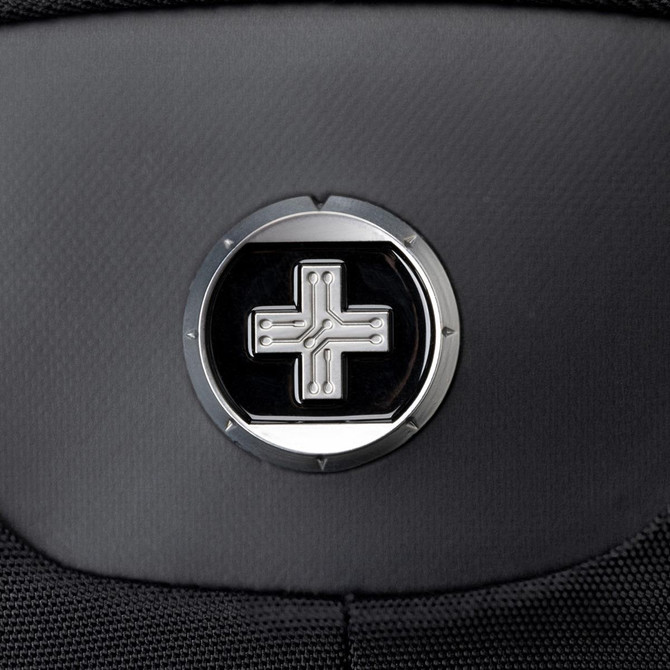 A close-up of a black backpack featuring a circular logo with a cross design in the centre.