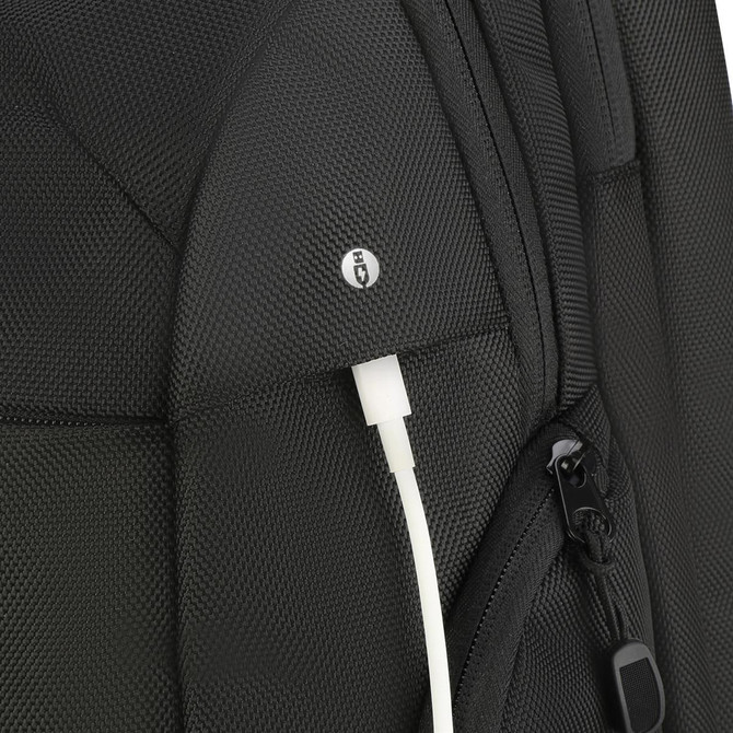 A black backpack featuring a textured surface and an external charging port with a white cable.