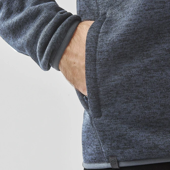 A grey polar fleece jacket featuring a side pocket and a fitted design at the cuffs. It has a logo on the hem.