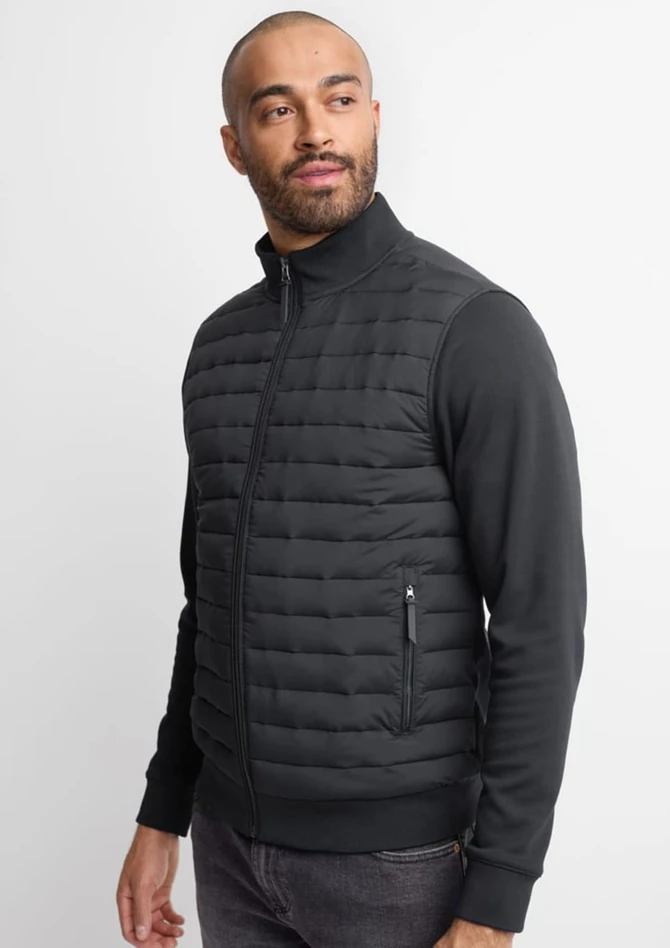A men's tailored jacket in black, featuring quilted detailing and a zippered pocket on the side.
