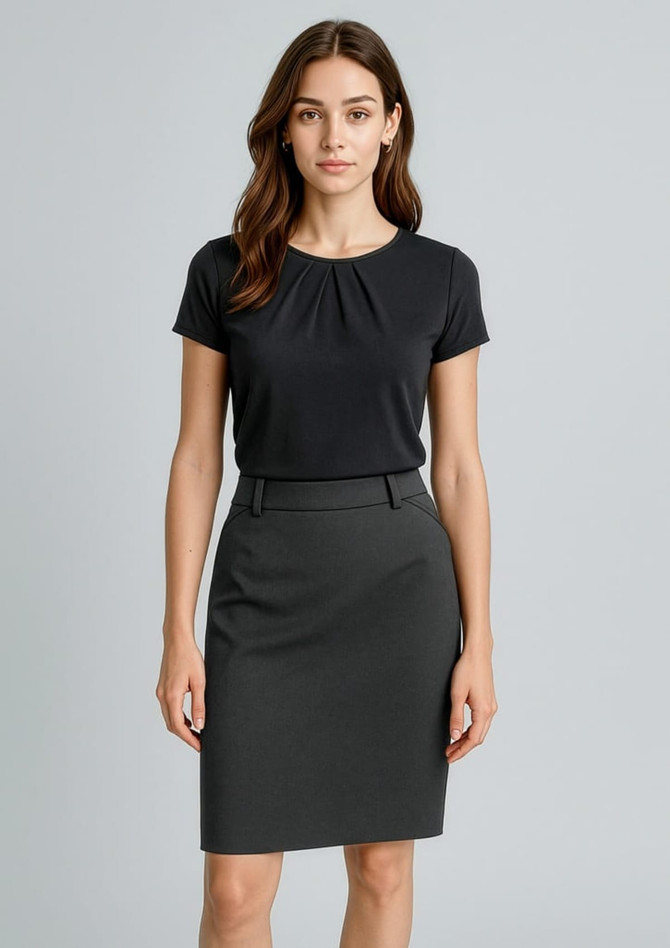 A woman stands wearing a black top and a dark grey pencil skirt. The skirt features a sleek design and a waistband.