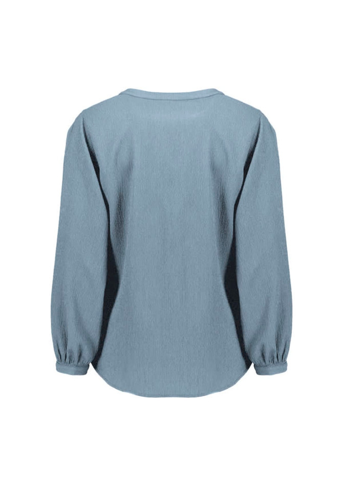 A women's long sleeve blouse in light blue, featuring a ruché design and a relaxed fit. It has a logo on the back.